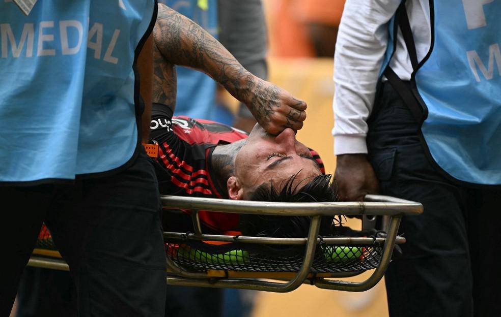 Erick Pulgar sai de maca em Flamengo x Bayern, com suspeita de fratura no pe direito