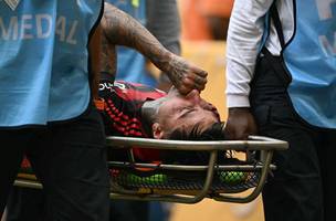 Erick Pulgar sai de maca em Flamengo x Bayern, com suspeita de fratura no pe direito (Foto: PATRICIA DE MELO MOREIRA / AFP)