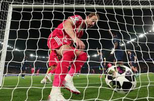Harry Kane vai buscar a bola no fundo do gol apos um dos gols do Bayern de Munique contra o PSG. (Foto: Reuters)